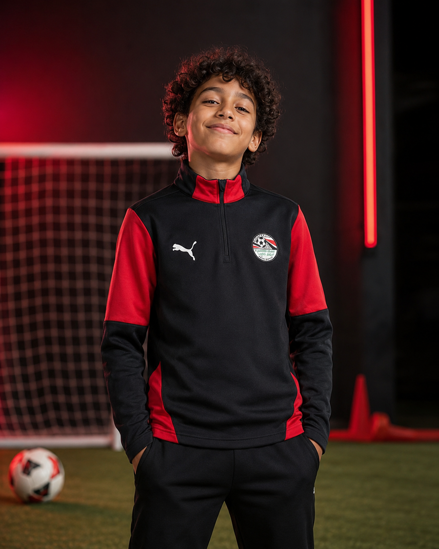 طفل يرتدي توب تدريب منتخب مصر الأسود والأحمر المتوفر في Toys Station Express